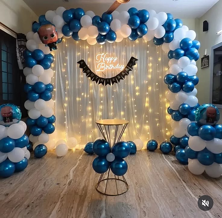 Boss Baby birthday decoration with chrome blue and white balloon arch, character foil balloons, neon sign and fairy lights white backdrop