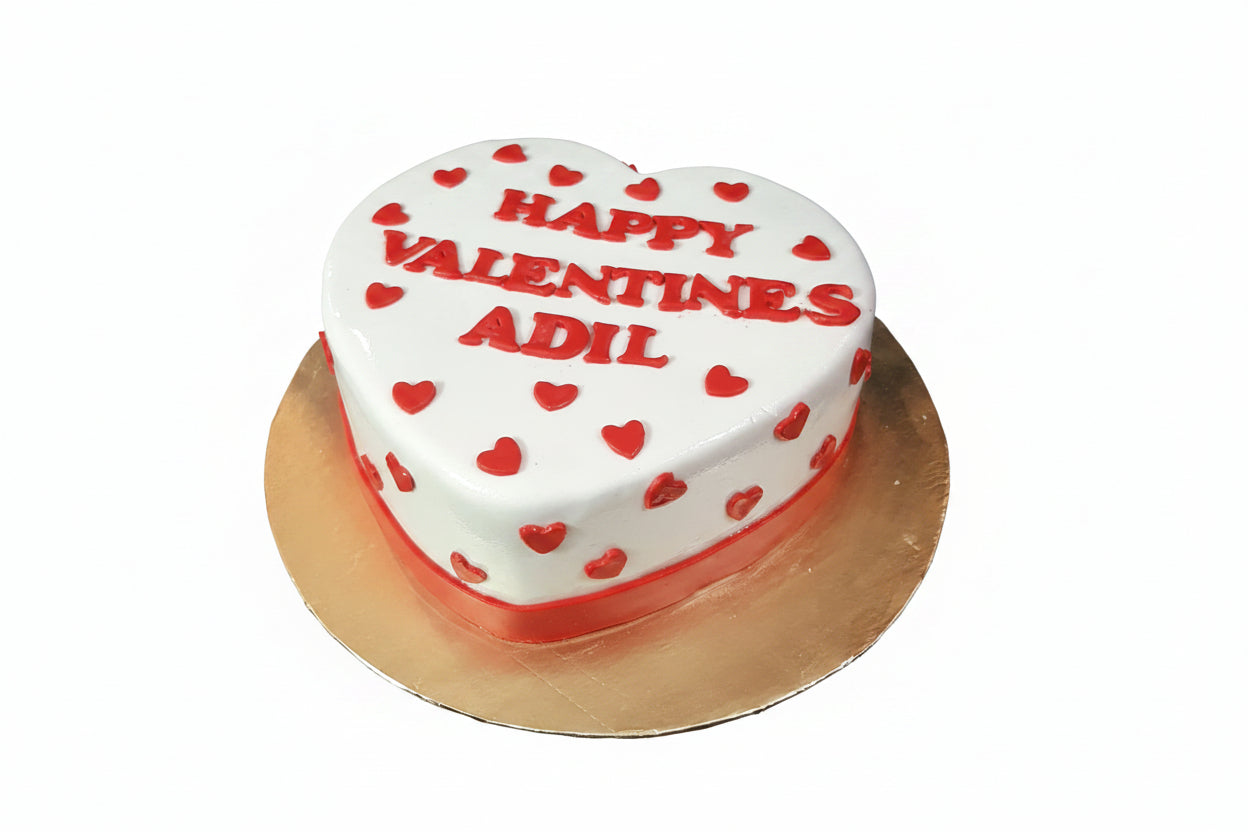 Heart-shaped white fondant anniversary Valentine cake with red mini hearts and custom name lettering by Marbella Cakes