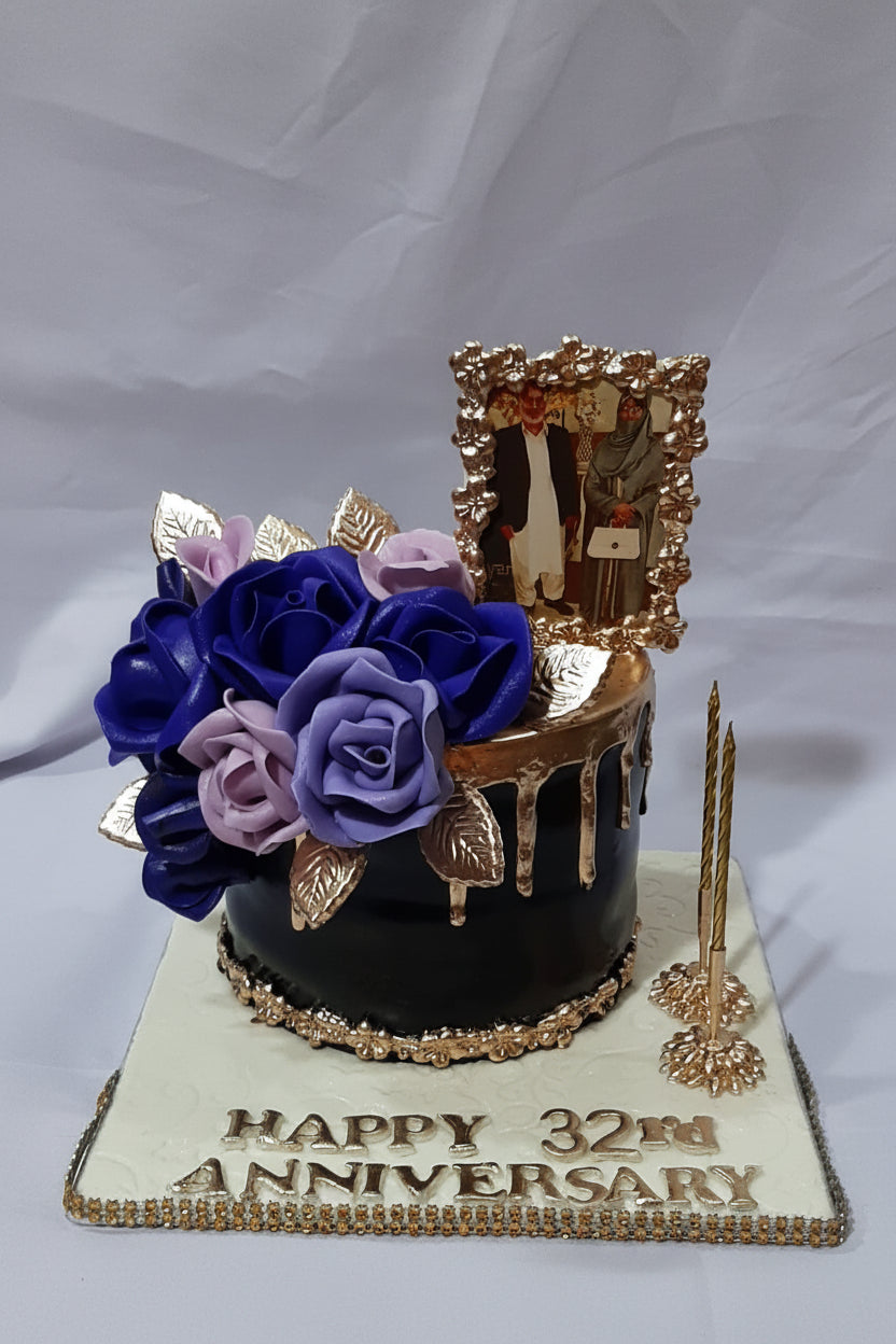 Happy 32nd Anniversary black gold drip cake with blue lavender roses, gold photo frame topper and pearl decorations by Marbella Cakes