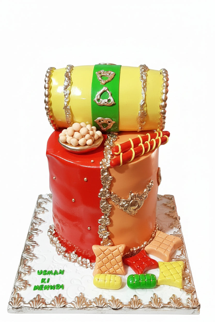 Two tier Mehndi cake with yellow dholki topper red orange base mehndi sticks and cushions