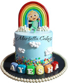 CoComelon Rainbow Sky Cake with blue buttercream, fondant rainbow topper, JJ character cutout, cloud decorations, and personalized name letter blocks