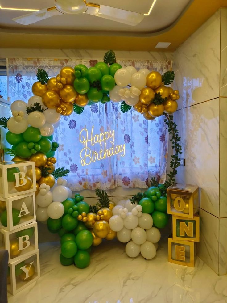 Baby One 1st birthday decoration with green gold white balloon arch, BABY letter boxes, ONE gold boxes and Happy Birthday neon sign
