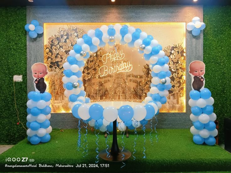 Boss Baby birthday decoration with blue and white balloon ring arch, Happy Birthday neon sign, Boss Baby character cutout standees and green grass wall backdrop