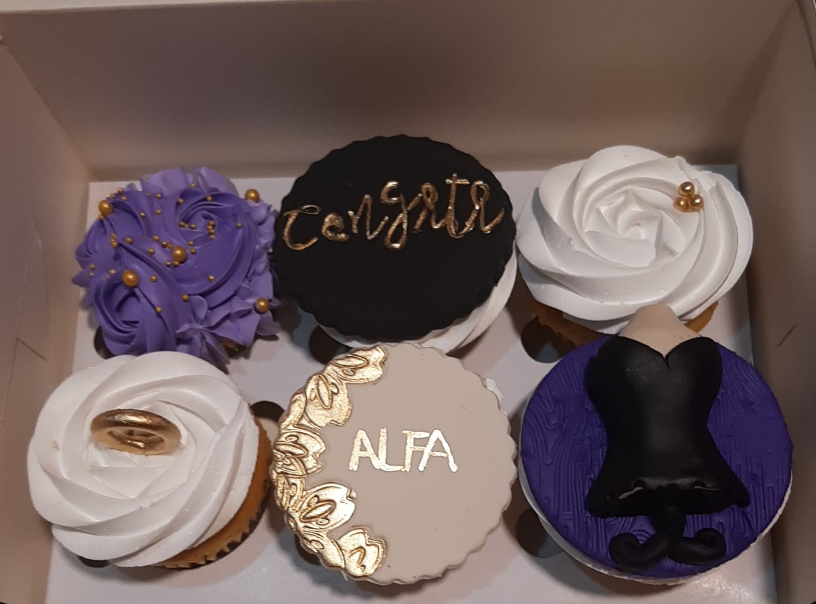 Box of 6 elegant congratulations cupcakes in purple black and white fondant with gold lettering, rosette swirls, gold ring topper, corset topper and personalized name
