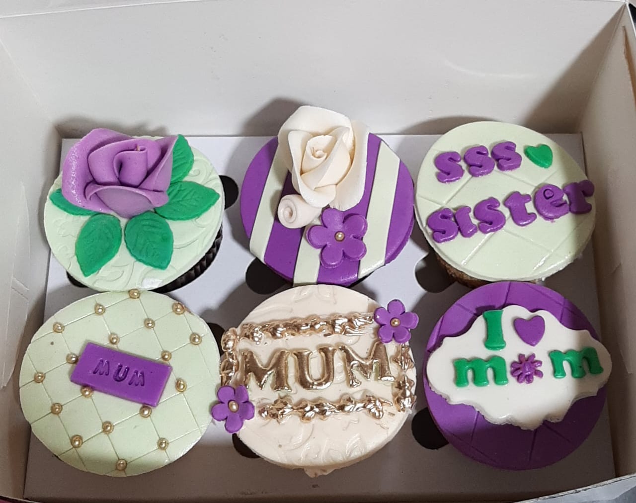 Box of 6 Mother's Day cupcakes in purple and mint fondant with MUM gold lettering, purple rose topper, quilted design, sister lettering and I Love Mom message