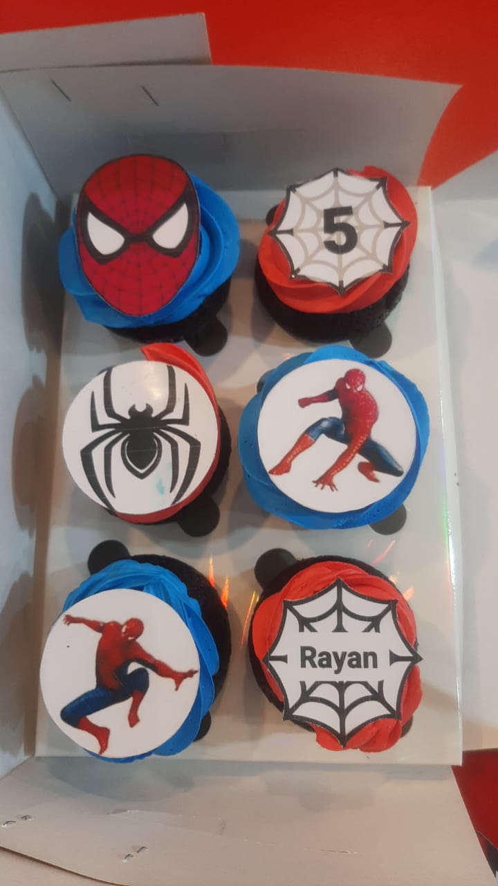 Box of 6 Spider-Man birthday cupcakes with blue red black buttercream, 3D fondant Spider-Man mask topper, edible image toppers with logo action pose and personalized name on spiderweb