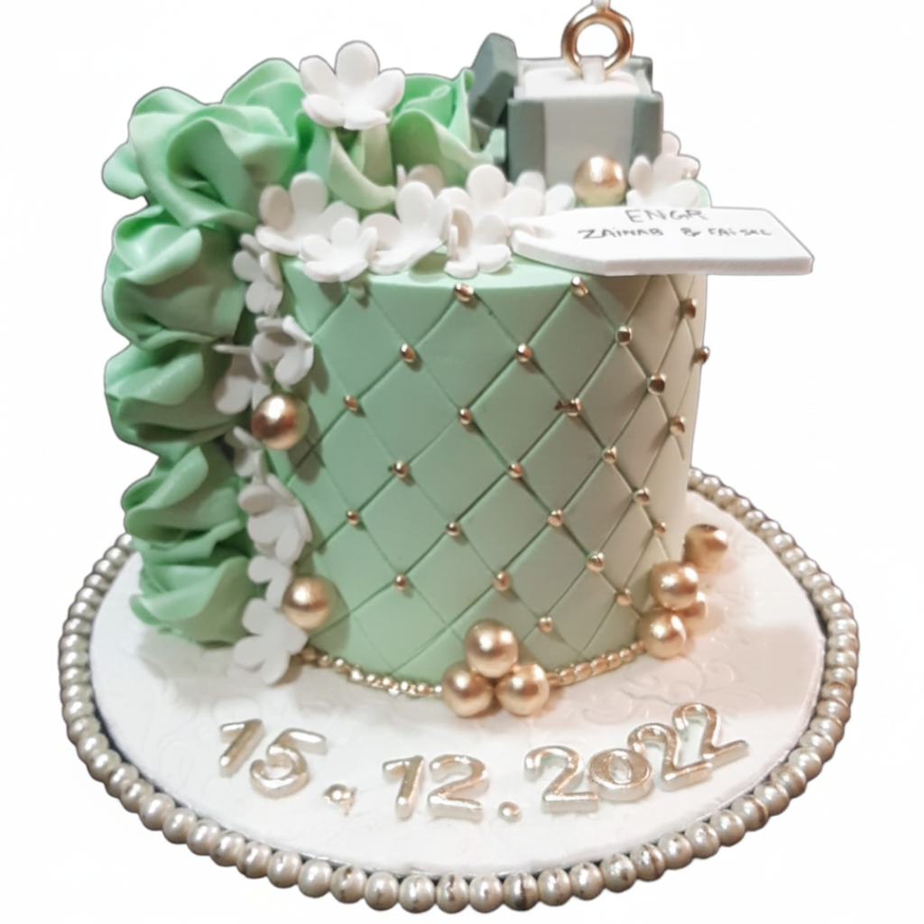 Mint green quilted engagement cake with ring box topper, ruffle flowers, gold pearl accents and silver date lettering on white background